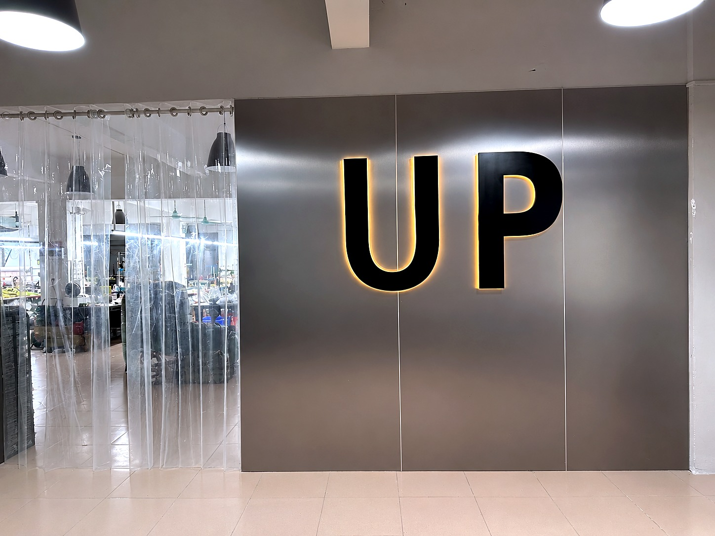 Illuminated UP sign at the entrance to the Guangzhou production space